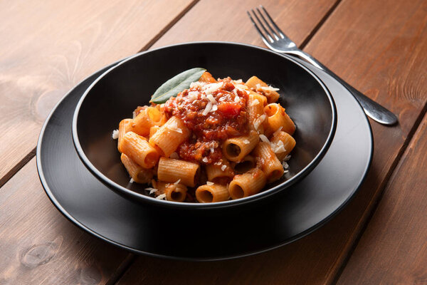 Dish of delicious rigatoni with meat sauce and mediterranean herbs, Italian cuisine
