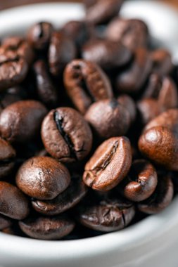 Kahverengi kahve çekirdekleri beyaz fincanda.