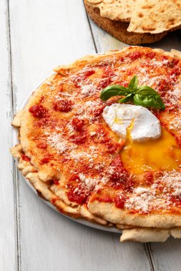 Pane frattau, geleneksel Sardunya tarifi koyun suyuna batırılmış ve üstüne domates sosu, pekorino ve haşlanmış yumurta, İtalyan yemeği.