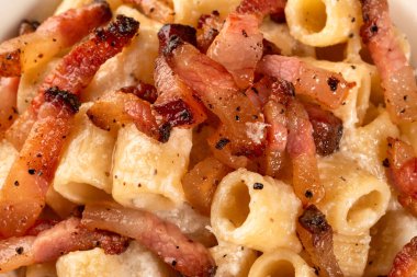 Lezzetli mezze maniche alla gricia, pekorino, guanciale ve karabiberli geleneksel bir makarna tarifi Roma mutfağı, İtalyan makarnası, Avrupa yemeği.