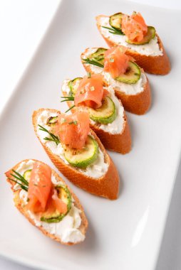 Somonlu crostini, beyaz tabakta krem peynir ve kabak.