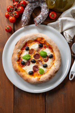 Salamlı, zeytinli, mozarellalı ve domates soslu pizza.