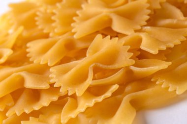 Beyaz arka planda farfalle şeklinde çiğ makarna.