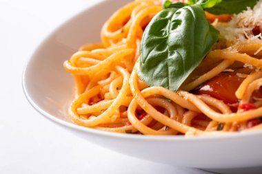 Beyaz arka planda domates soslu, peynirli ve fesleğenli spagetti..