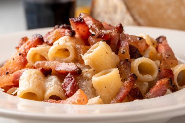 Lezzetli mezze maniche alla gricia, pekorino, guanciale ve karabiberli geleneksel bir makarna tarifi Roma mutfağı, İtalyan makarnası, Avrupa yemeği.