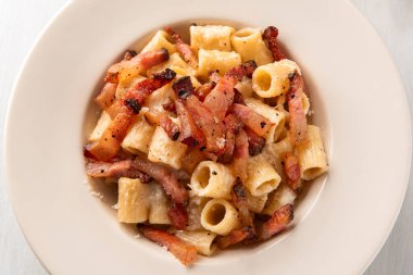 Lezzetli mezze maniche alla gricia, pekorino, guanciale ve karabiberli geleneksel bir makarna tarifi Roma mutfağı, İtalyan makarnası, Avrupa yemeği.