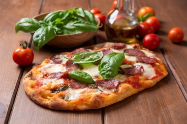 Mozarella soslu lezzetli pizza, domates sosu, domuz sosisi ve siyah zeytin, İtalyan yemeği.