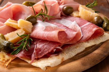 Peynirli, jambonlu ve aperatifli lezzetli mezelerin yakın plan görüntüsü.