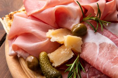 Peynirli, jambonlu ve aperatifli lezzetli mezelerin yakın plan görüntüsü.