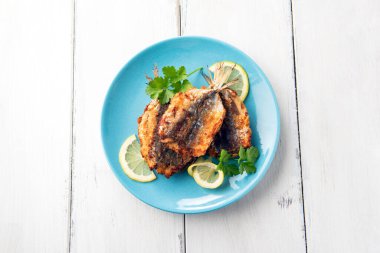 Mavi tabakta lezzetli kızarmış balıkların yakın plan görüntüsü.