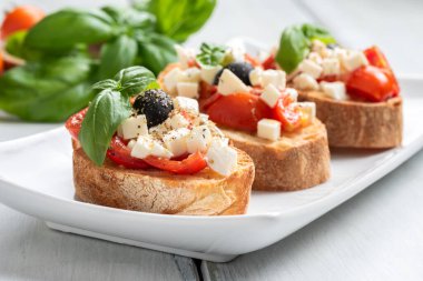 close-up view of delicious italian bruschetta with olives on white table clipart