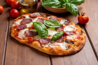 Ahşap arka planda lezzetli bir pizza, yakın plan. Yiyecek. 