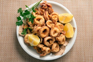 Limon dilimleriyle servis edilen kızarmış kalamar.