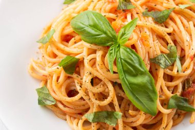 Domates soslu vejetaryen spagetti ve fesleğen yaprağı.