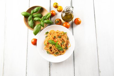 Domates soslu vejetaryen spagetti ve fesleğen yaprağı.