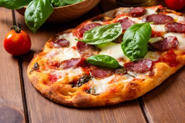 Salamlı ve fesleğenli İtalyan pizzası.