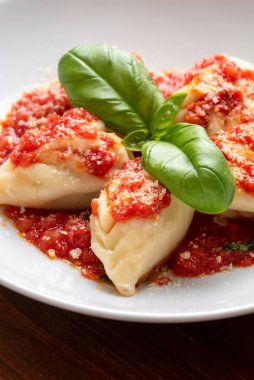 Culurgionis, traditional sardinian pasta filled with potato, pecorino and mint, topped with tomato sauce, italian food clipart