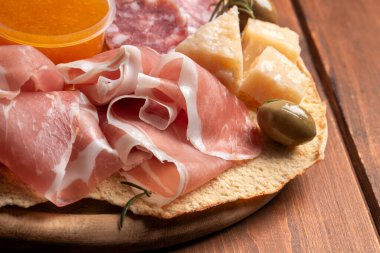 Dilimlenmiş salam, zeytin, peynir ve parmesanlı tabak, İtalyan aperatifleri.