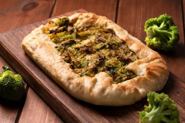 Savory pie stuffed with onion and broccoli, vegetarian food clipart