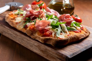 İtalyan pizzası mozzarella, domates sosu, fırında jambon ve haşhaş tohumlu.