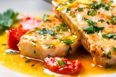 Beyaz tabakta domatesli fırında balık satıcısı.