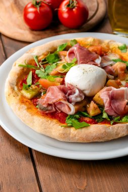 Ahşap arka planda jambonlu ve mantarlı pizza