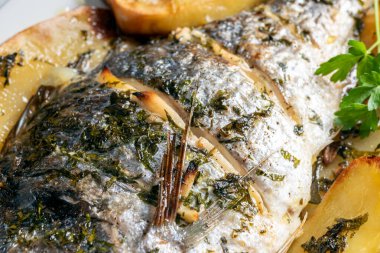 Fırınlanmış deniz çipurası, patates ve Akdeniz yemeği.