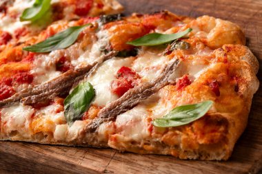 Biftekli İtalyan pizzası, mozzarella ve fesleğen yapraklı.