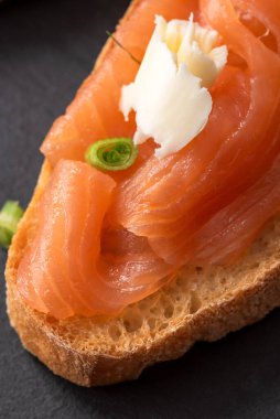 Füme somon, krem peynir, salatalık ve maydanozlu sandviç.