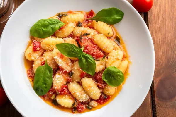 Tabağında domates sosu olan gnocchi yakın çekim.