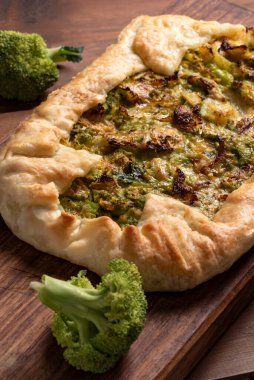 Ahşap tahtada brokolili fırında tuzlu turta.  