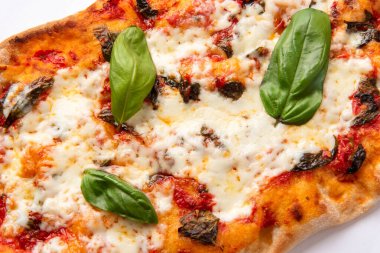 Yakın çekim, peynirli ve fesleğenli fırınlanmış pizza manzarası.  