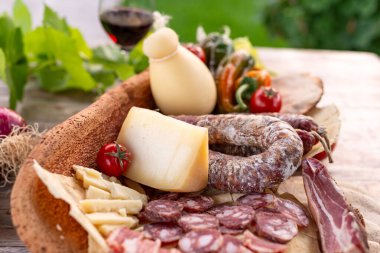 Tahta tabakta çeşitli peynir ve etler.