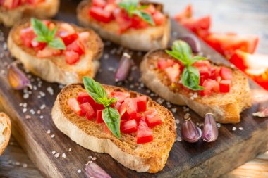 Bruschetta domates ve fesleğen ahşap tahta üzerinde