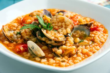 İstiridye ve deniz ürünleri soslu kuskus.