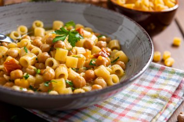 Nohut, domates ve dereotla süslenmiş makarna.