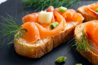 Taze dereotuyla süslenmiş füme somon bruschetta.