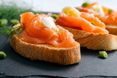 Kızarmış ekmeğin üzerinde dinlenen füme somon dilimleri.