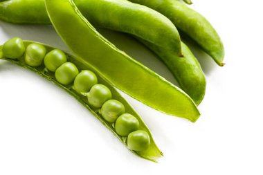 Taze yeşil bezelye kabukları beyaz arkaplanda dinleniyor