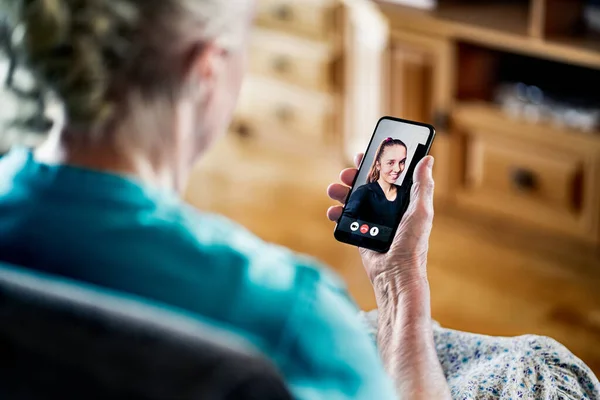Old senior woman having a phone video call with young lady. Family communication. Mobile technology. Grandma using smartphone videocall. Happy relationship with grandparent. Elder person and cellphone