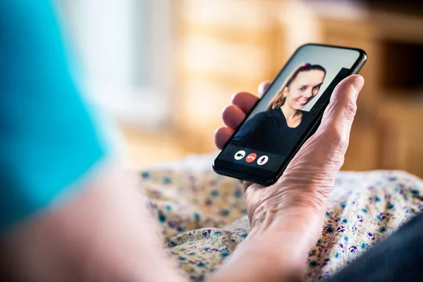 Video call with family. Mobile phone videocall. Old senior lady and young woman. Grandma and granddaughter talking online. Happy relationship between relatives. Smiling face. Communication technology.