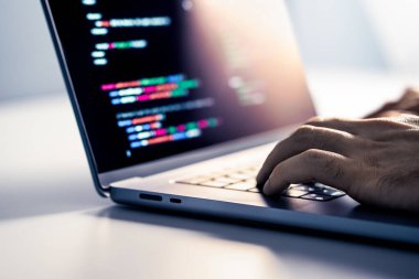 Hacker ve kötü amaçlı bilgisayar yazılımı. Sahtekarlık web sitesi kodu ekranda. Programcı dizüstü bilgisayarla ağ güvenliği geliştiriyor. Veri gizliliği hackleme ve siber güvenlik. Çevrimiçi suç. Suçlu eller klavyede.