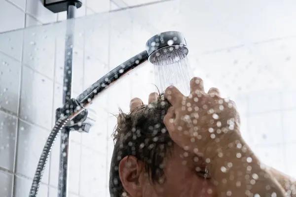 Washing hair with shampoo. Man in shower. Cold or hot water. Conditioner, gel or foam. Hairline, loss, dandruff or damage concept. Dry itchy scalp. Healthy happy male in gym or hotel bath.