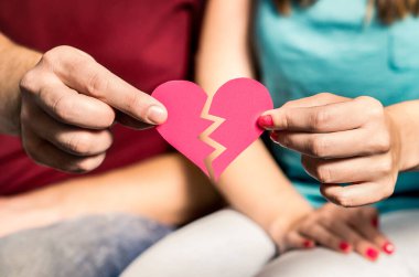 Boşanma, ayrılma ya da ayrılma. Parçalanmış kağıt kalp bir çiftin elinde. Eşleşmeyi ve aşkı bulmak. Aldatma, aldatma, ihanet ya da ilişkide güven sorunları. Kadınla erkeği ayırın..