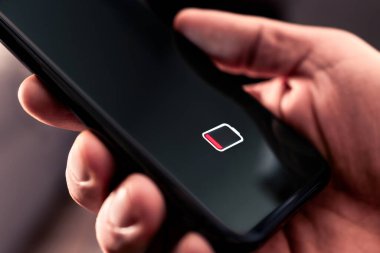 Düşük şarjlı telefon bataryası. Elektriği olmayan bir cep telefonu. Enerji sızıntısı. Boş yük ve ölü akıllı telefon. Mobil yaşam simgesini yeniden yükle. El ele tutuşan adam. Bozuk teknoloji..