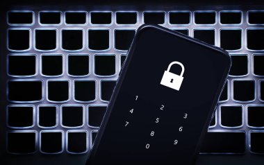 Şifreli telefonda veri gizliliği. Laptop klavyesinde akıllı telefon. Kişisel bankayı hackerdan, siber dolandırıcılıktan ya da online dolandırıcılıktan korumak için kilitleyin. 2fa onayı ile koruma. Pin numarası.