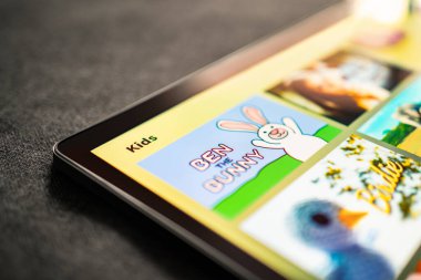 Çocuklar için tabletteki çizgi film videoları. Aile çocukları için oyun ya da film. Çocuk için animasyon dizisi. Mockup TV kanalı servisi. Ekran süresi ve internet limiti kavramı. Pad ile çevrimiçi oyun.