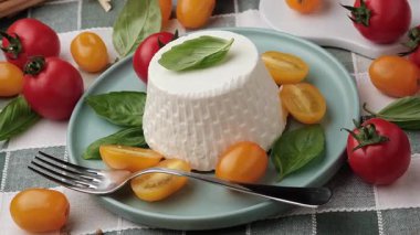 Tabakta taze ricotta ve domates var. Yakın plan.