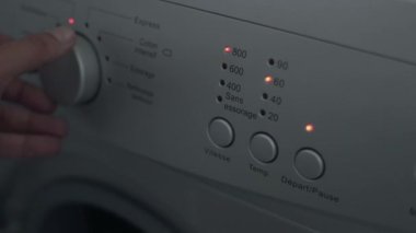 Çamaşır Makinesinde İnsan Seçme Programı 'nı kapat. Parmak, çamaşır makinesini çalıştırmak için düğmeye bas. Ev aletleri