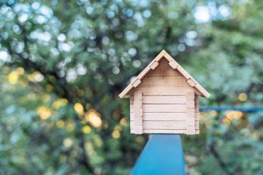Teras korkuluğunda duran küçük ahşap ev. Ev, ev, ekolojik yapı konsepti..